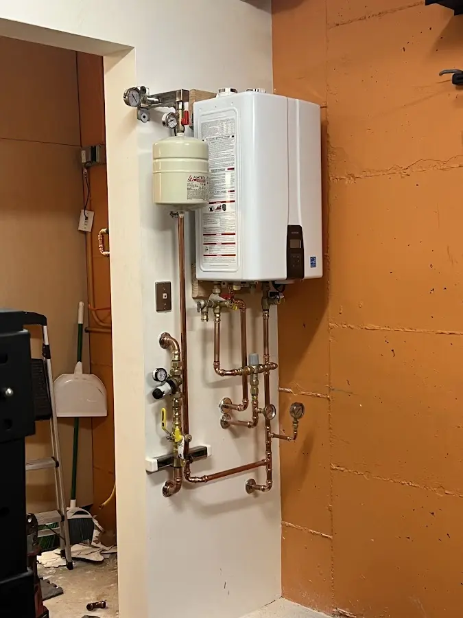 Plumbing technician inspecting water heater connections in Mirrormont